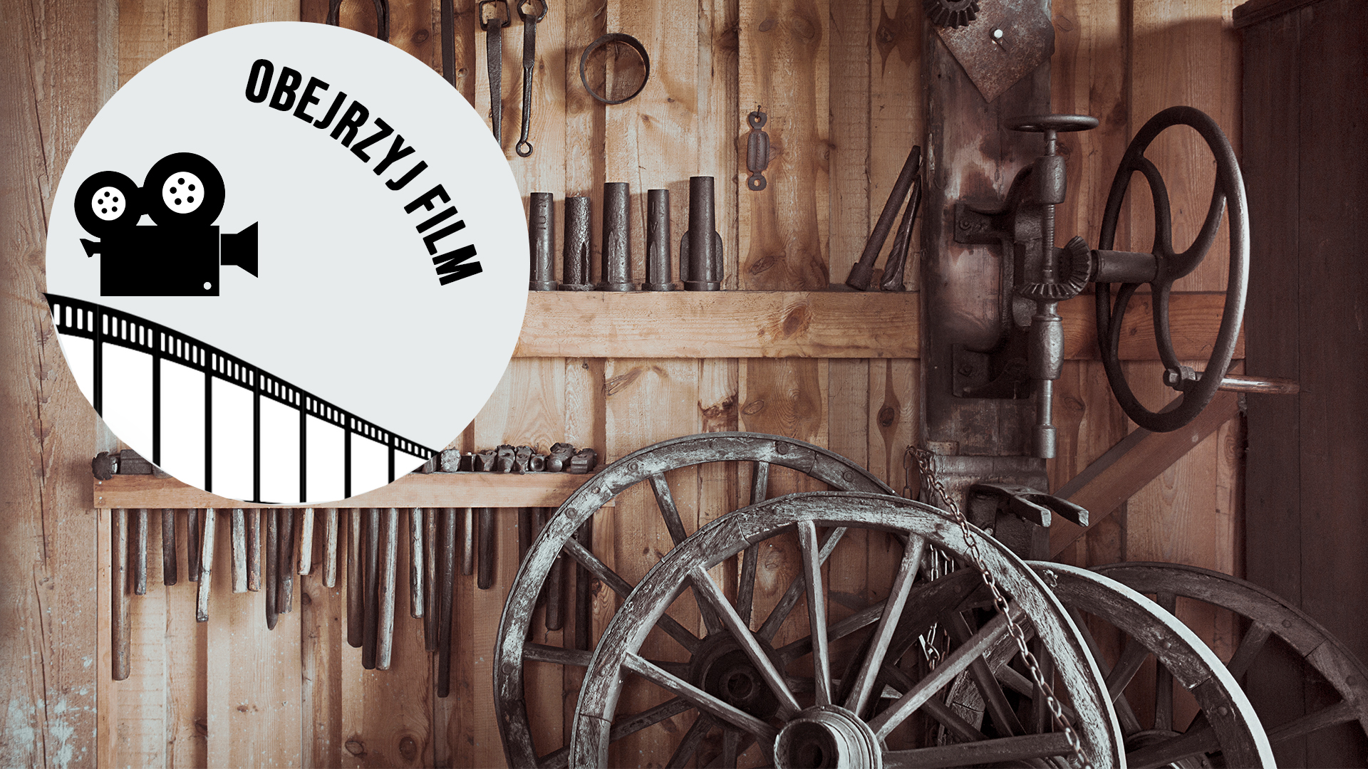 zdjęcie przedstawiające starą kużnię, na pierwszym planie wielkie koło od wozu, w tle młotki i narzędzia kowalskie