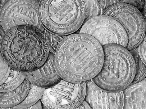 Na zdjęciu pokazane są rozsypane dirhamy z arabskimi napisami. Monety pochodzą ze skarbu z miejscowości Klukowicze w województwie podlaskim. Skarb ukryty został w początkach X wieku.