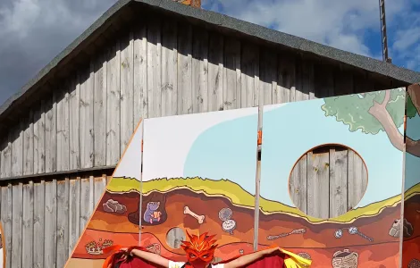 dziecko przebrane w strój ptaka feniksa na tle ścianki wystawowej 